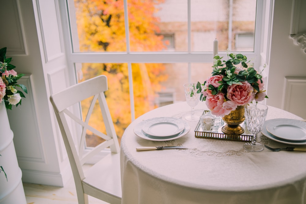 흰 테이블에 투명 유리 꽃병에 빨간 장미