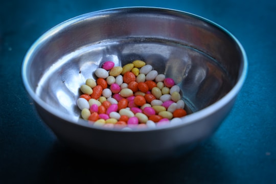 Close-up of a transparent BPA-free candy scoop bin with a stainless steel scoop resting on top.
