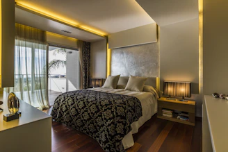 A serene bedroom with soft beige tones, plush bedding, and elegant black and gold decor.
