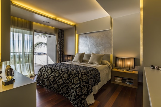 High-end bedroom featuring sleek black blinds complementing neutral tones and golden accents.