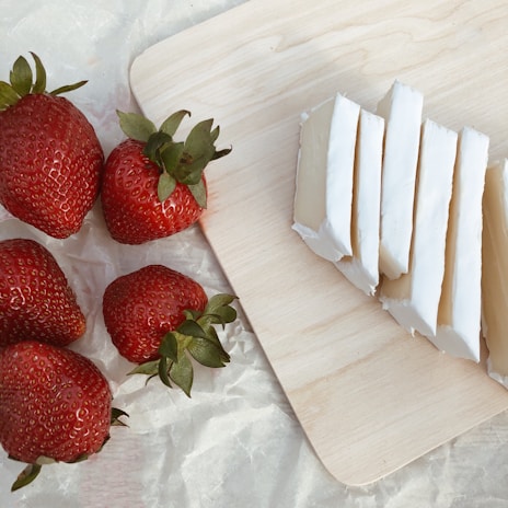 A close-up of a creamy mozzarella cheese ball on a wooden board.