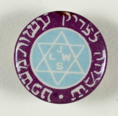 A circular button or badge features a Star of David in the center with the letters 'J L W S' inside the star. The star is enclosed by a blue circle and surrounded by purple with white script or lettering around the edge.