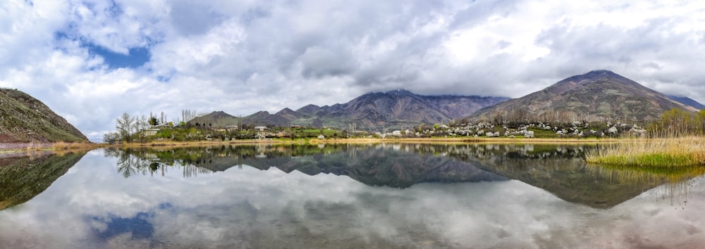 Specchio d'acqua vicino alla montagna sotto il cielo nuvoloso durante il giorno