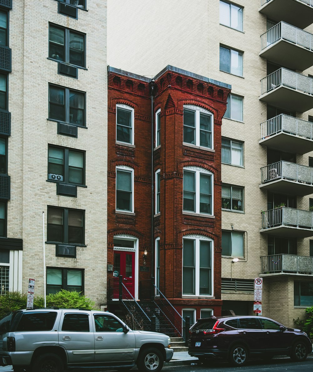 cars parked in front of brown building during daytime