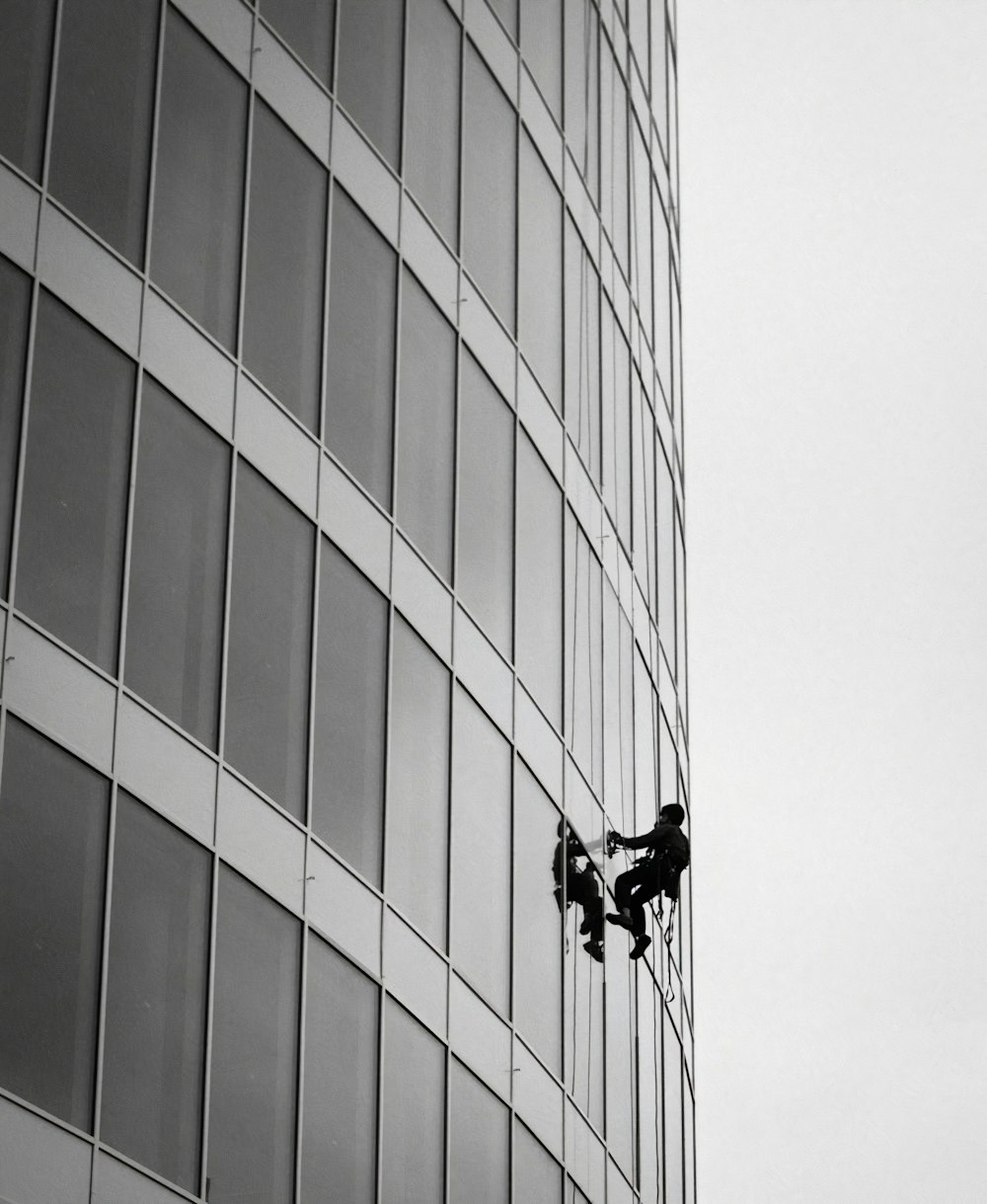 black and white photo of man riding bicycle