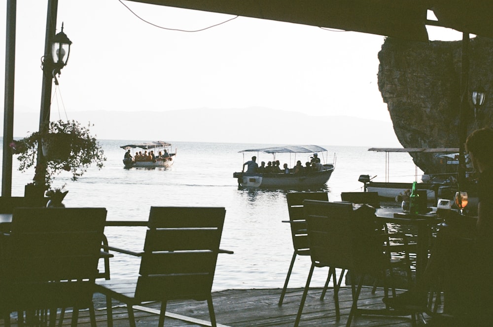 people sitting on chairs near sea during daytime