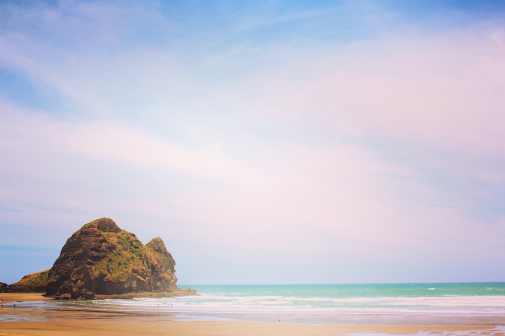 brown rock formation on sea shore during daytime