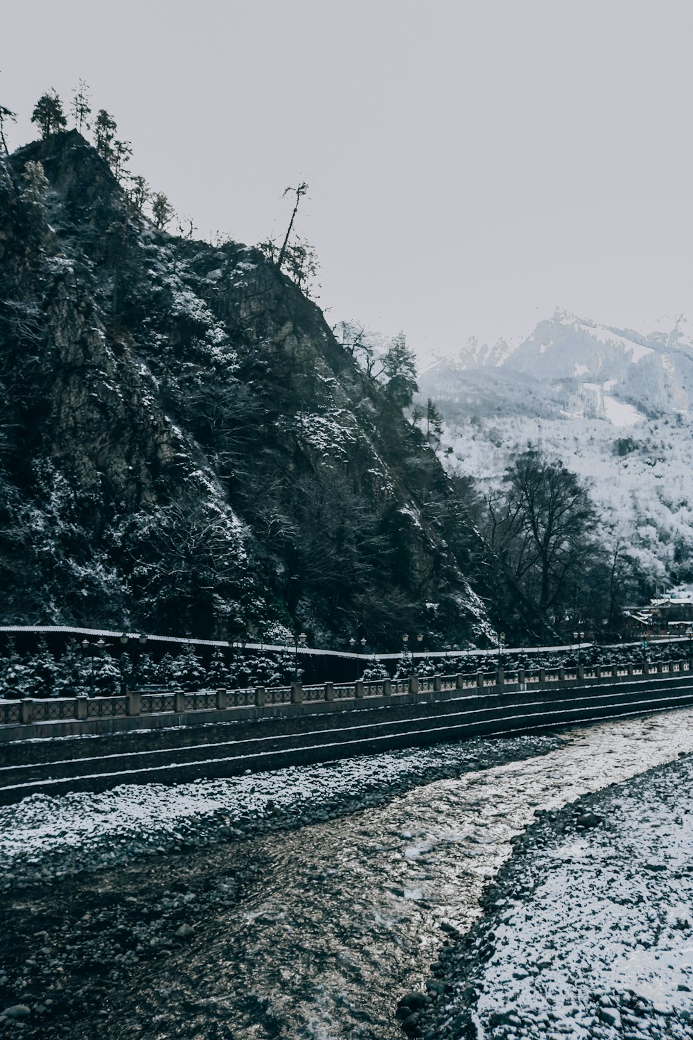 black metal train rail near trees and mountains during daytime