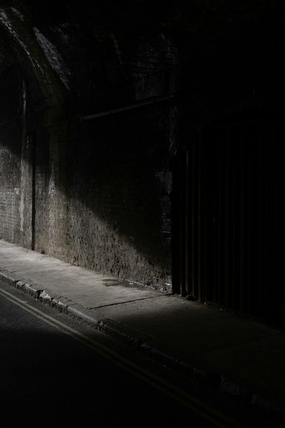 black wooden door beside gray concrete wall