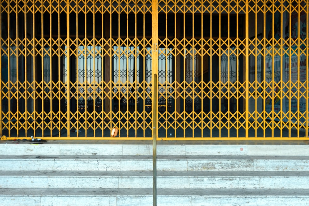 白いコンクリートの壁に黄色い金属の門