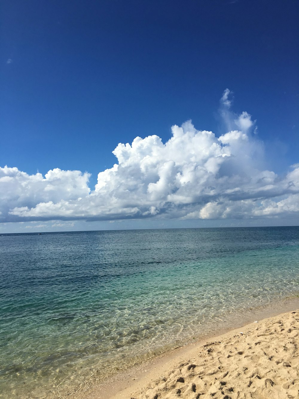 blue sea under blue sky and white clouds during daytime