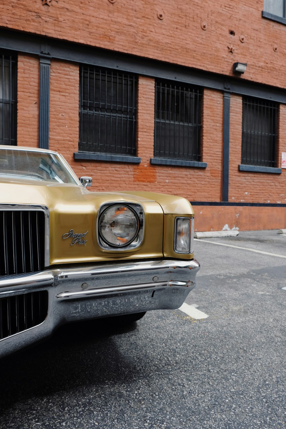 yellow car parked beside brown brick building