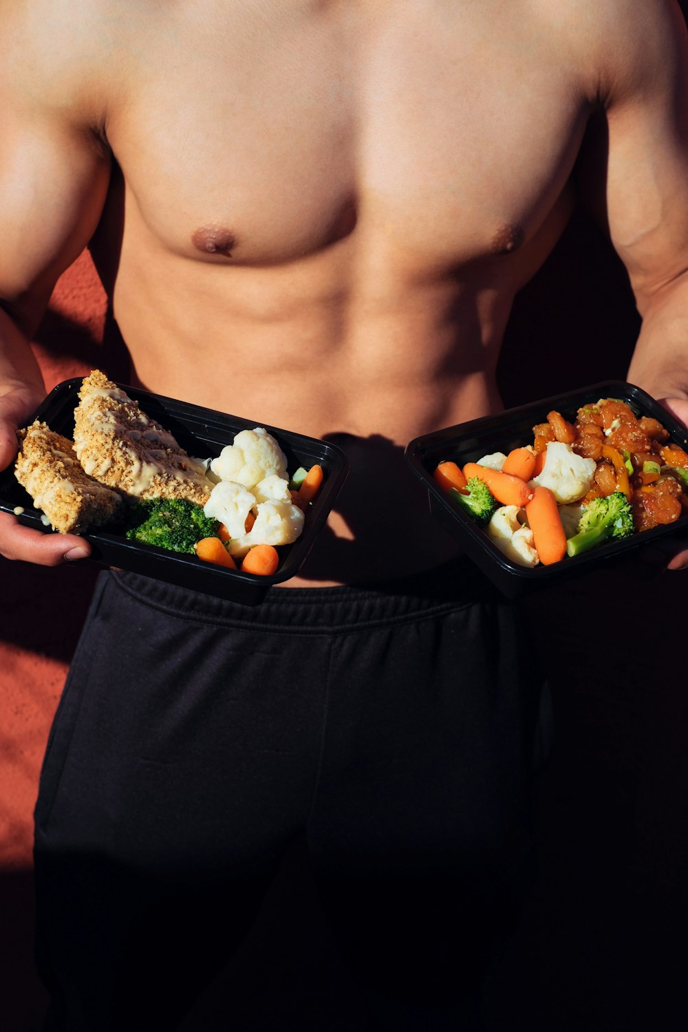 Oben-ohne-Mann in schwarzen Shorts mit gekochtem Essen