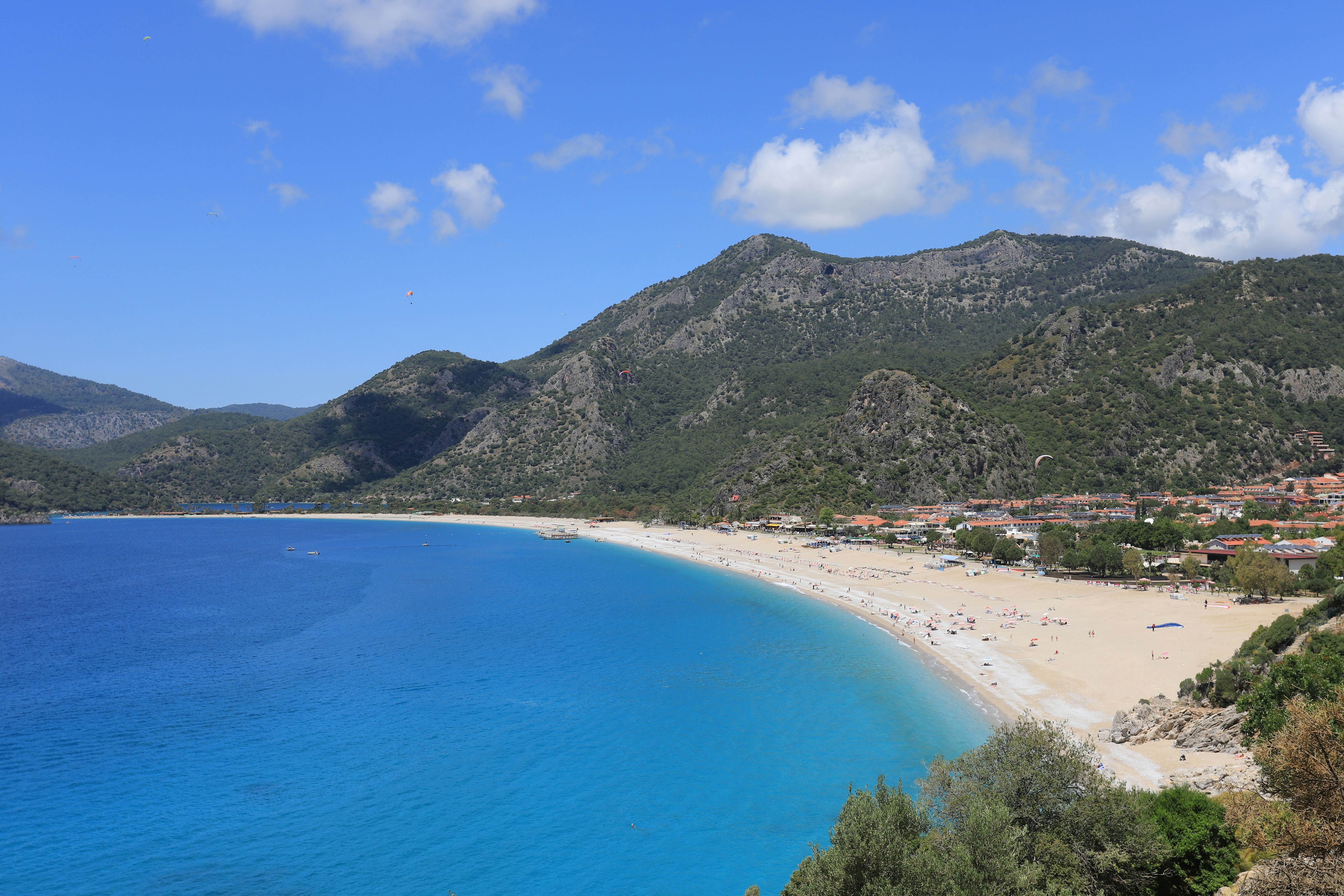 green mountain beside blue sea under blue sky during daytime