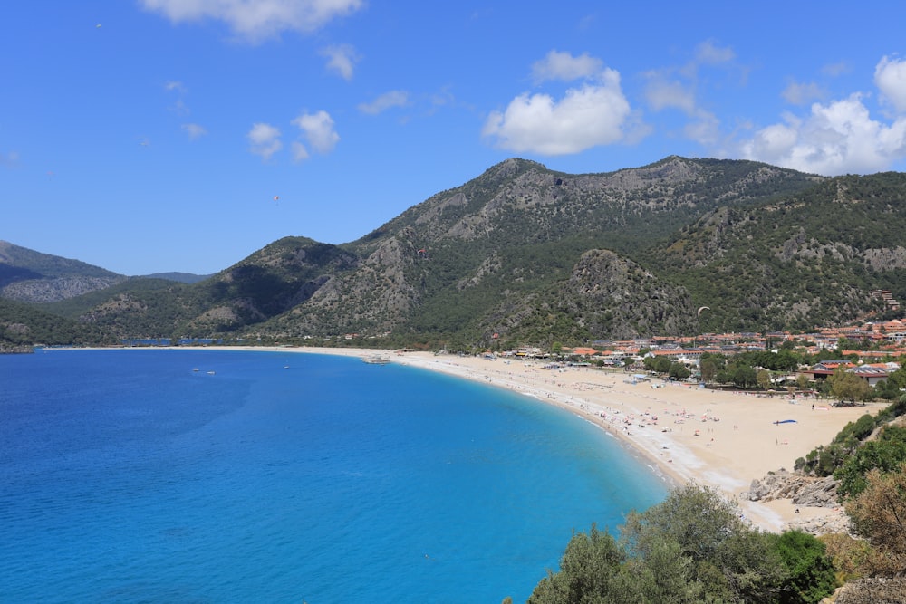 green mountain beside blue sea under blue sky during daytime