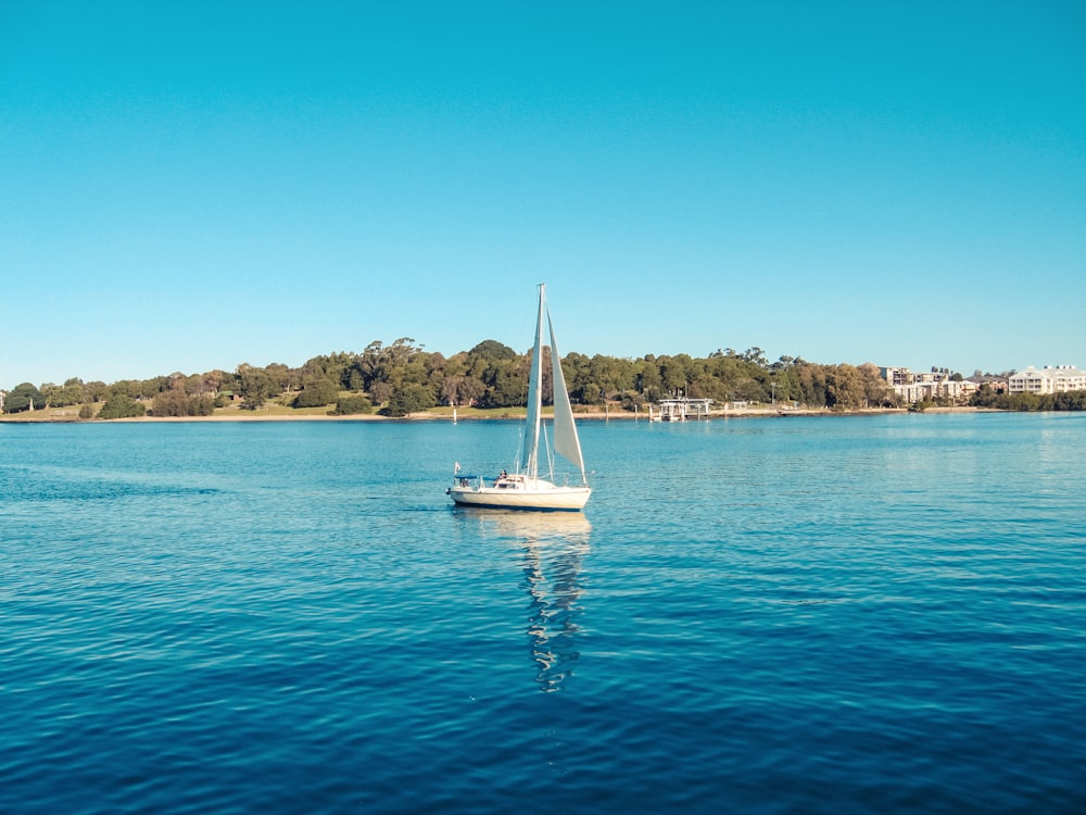 white sailboat on blue sea under blue sky during daytime