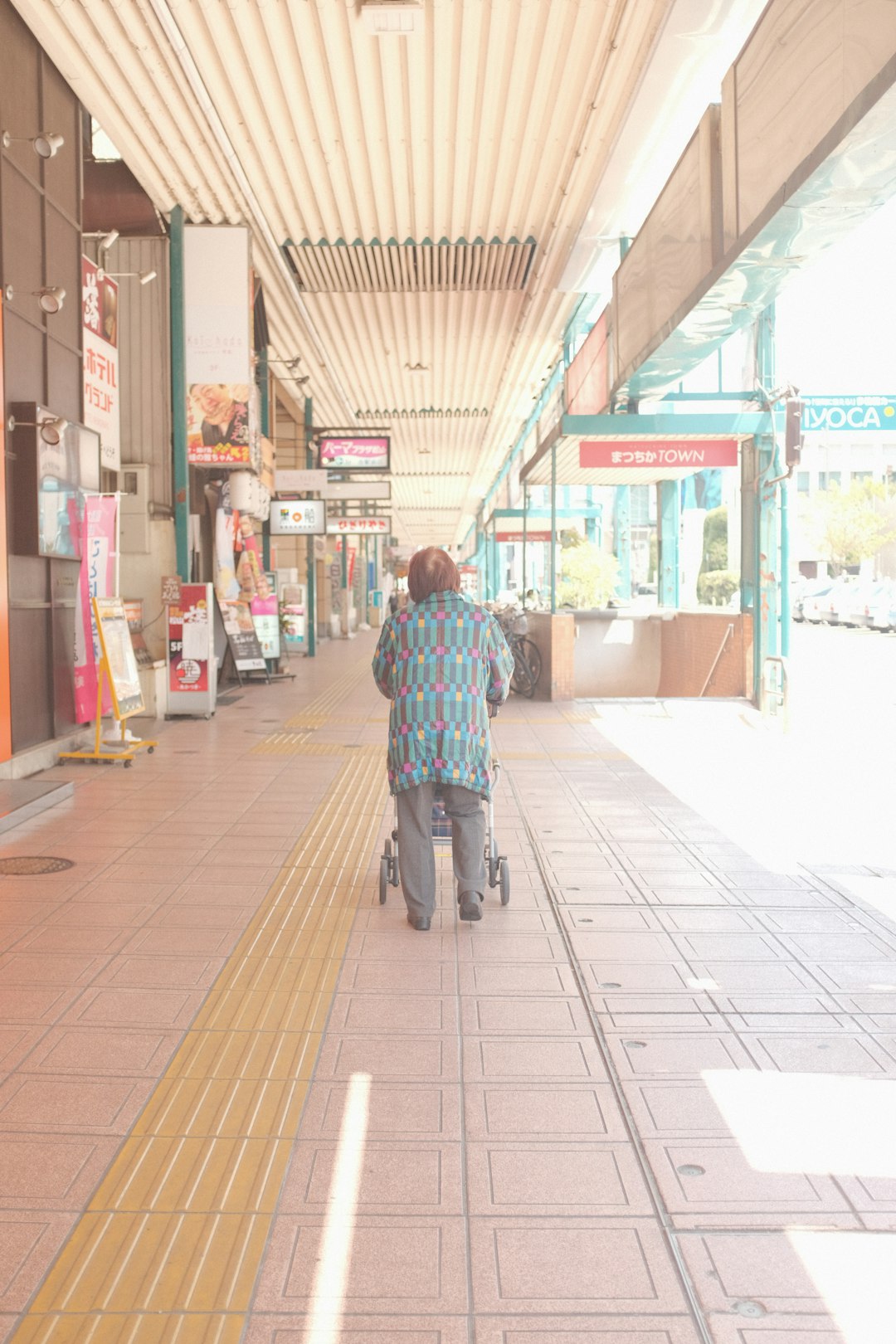 man in blue red and white plaid dress shirt riding on bicycle during daytime