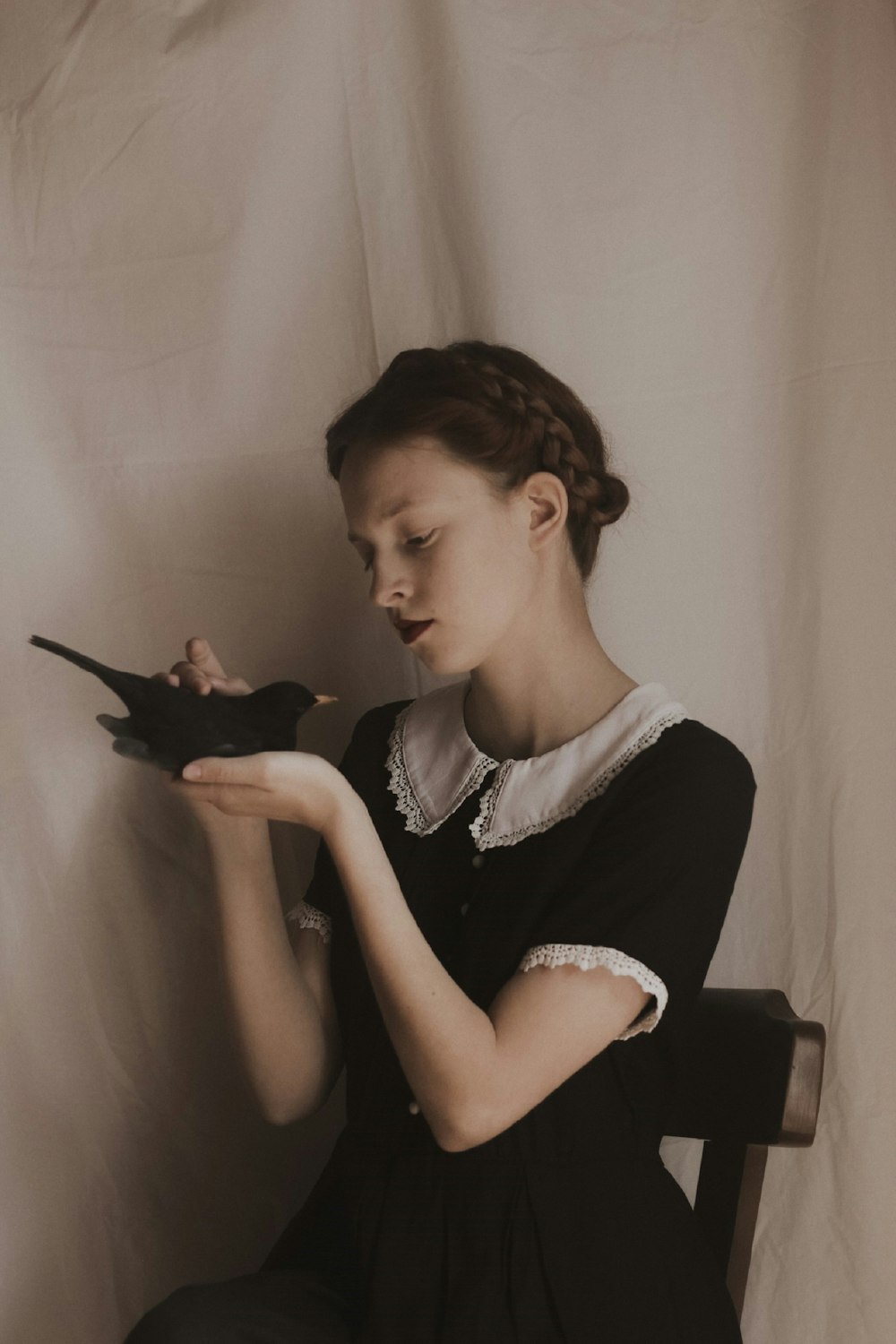 woman in black and white floral shirt holding black smartphone