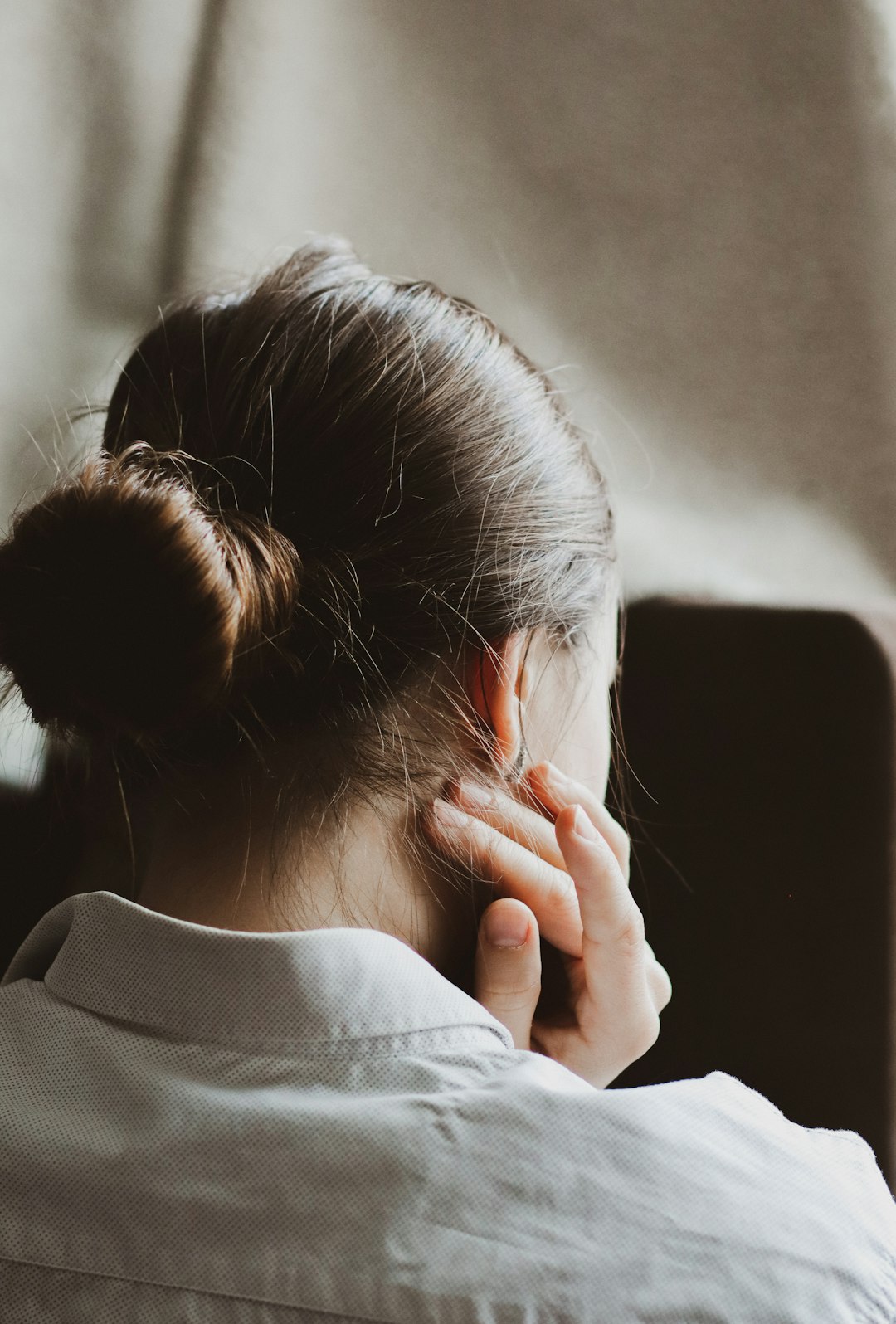 woman in white long sleeve shirt covering her face