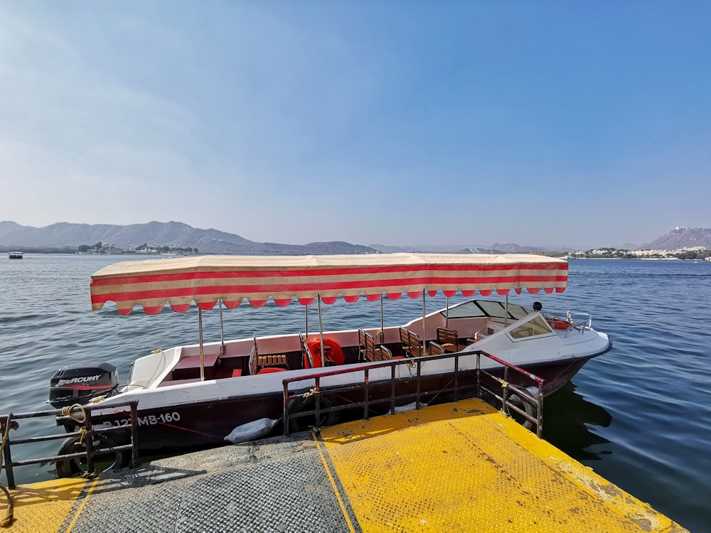 white and red boat on sea during daytime