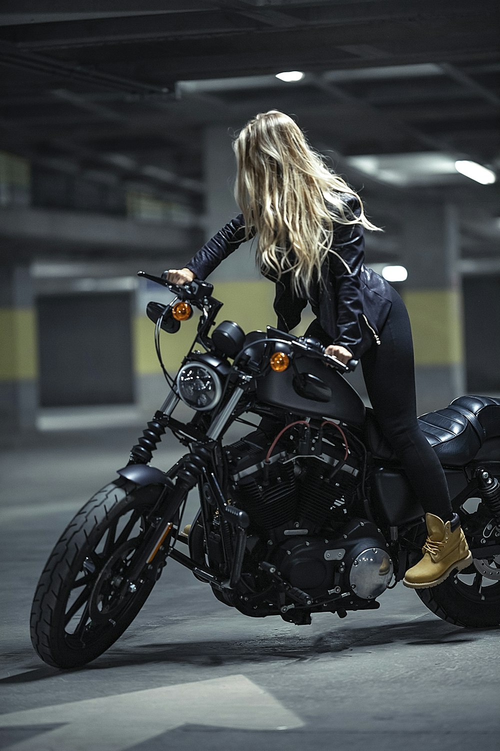 woman in black leather jacket riding black cruiser motorcycle