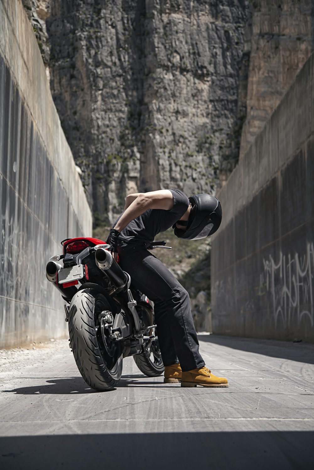 man in black helmet riding on red and black sports bike