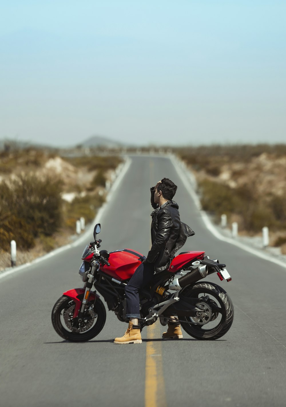 man in black jacket riding on black motorcycle on road during daytime