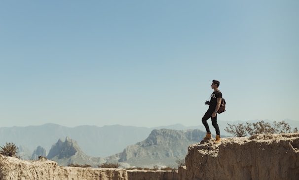 An adventurous traveler exploring a rocky cliffside.