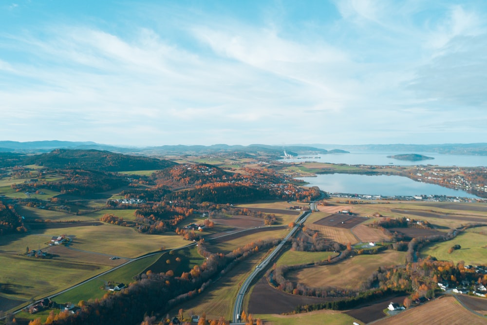 aerial view of green field near body of water during daytime