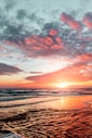 body of water under cloudy sky during sunset