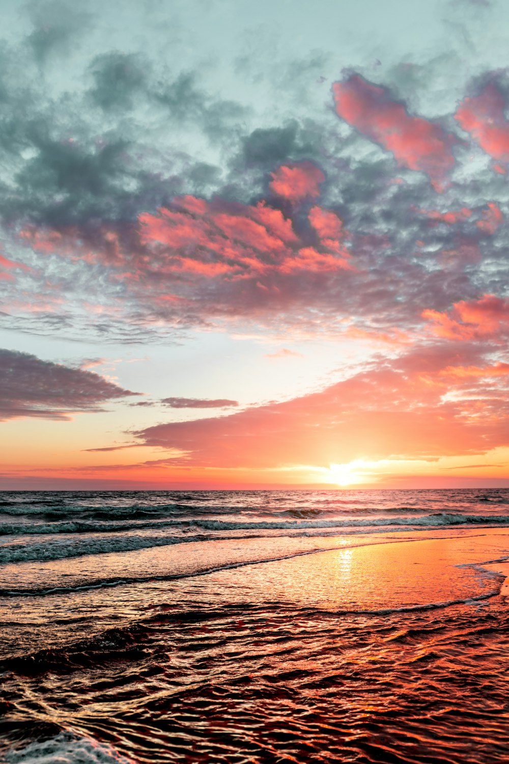 body of water under cloudy sky during sunset