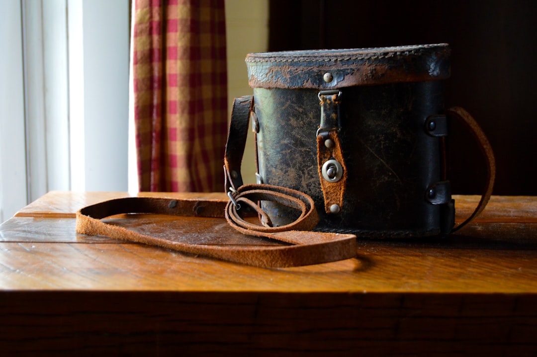 black leather handbag on brown wooden table