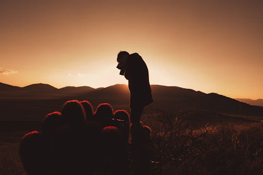 A dramatic cinematic desert sunset with a lone gunslinger silhouette.
