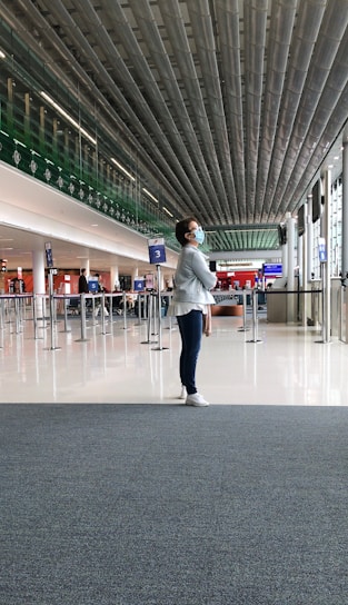 A welcoming agent greeting a patient at a sunny Chinese airport terminal.