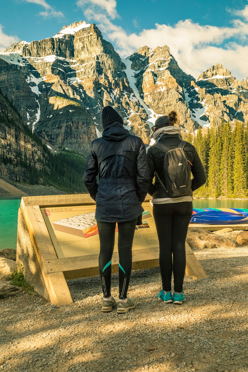 man and woman standing on brown wooden dock during daytime