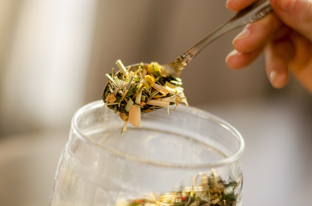 person holding clear glass bowl with pasta