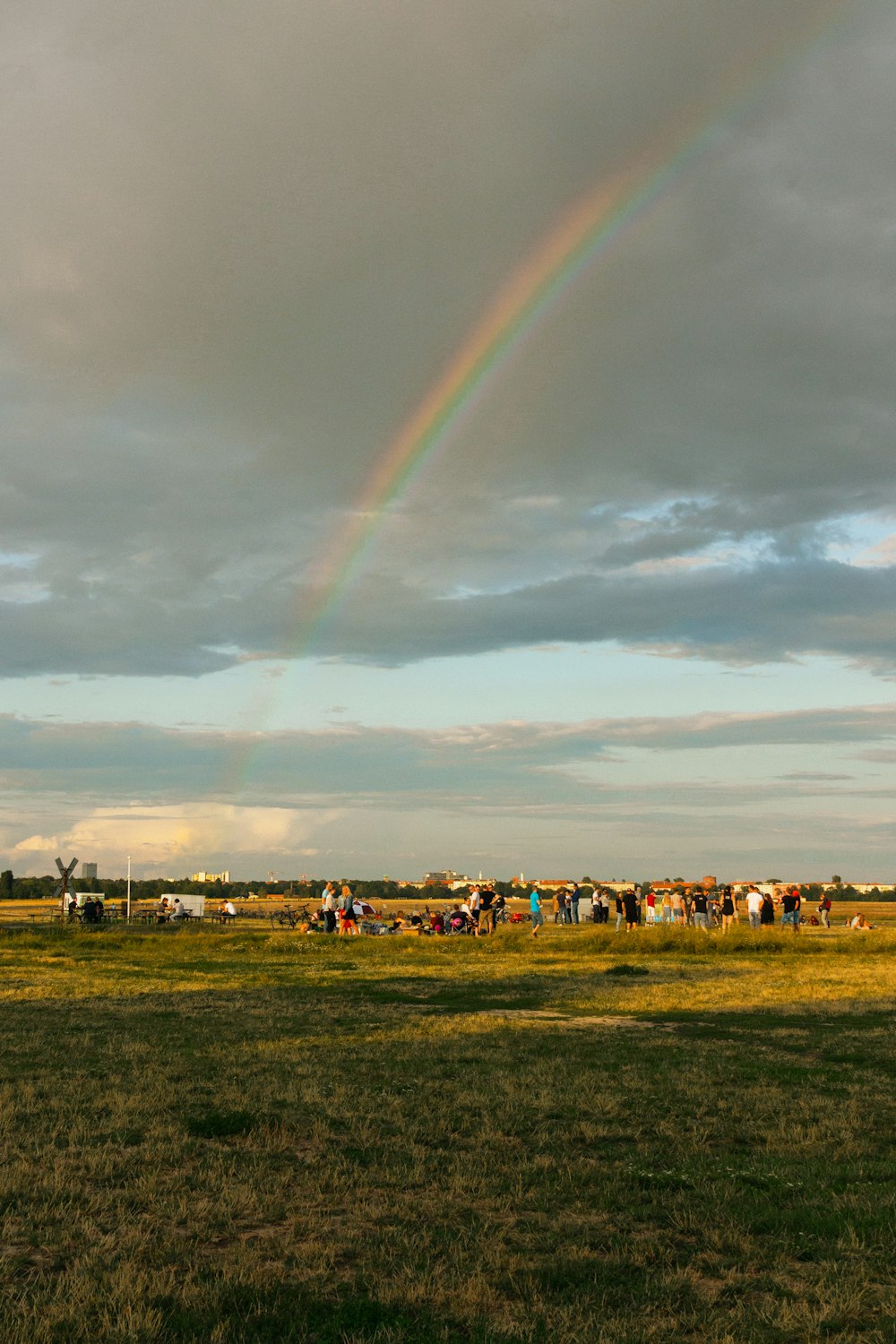 les gens sur le champ d’herbe verte sous l’arc-en-ciel