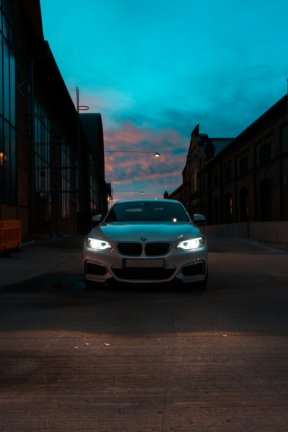 white bmw car parked on sidewalk during night time