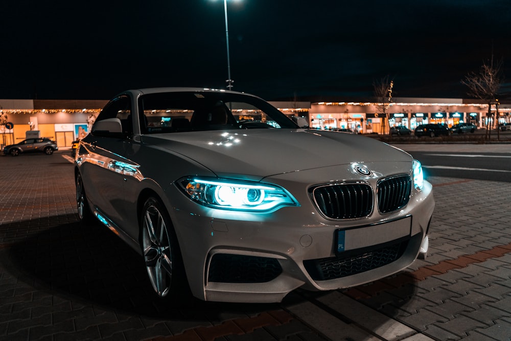 white bmw m 3 parked on parking lot during night time