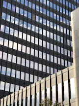 Modern office building facade with sleek glass windows reflecting the Hamburg skyline.