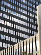 Modern office building with sleek glass facade reflecting the sky.