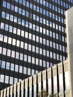 Modern office building with glass facade reflecting the city skyline.