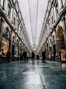 people walking on hallway between buildings during daytime