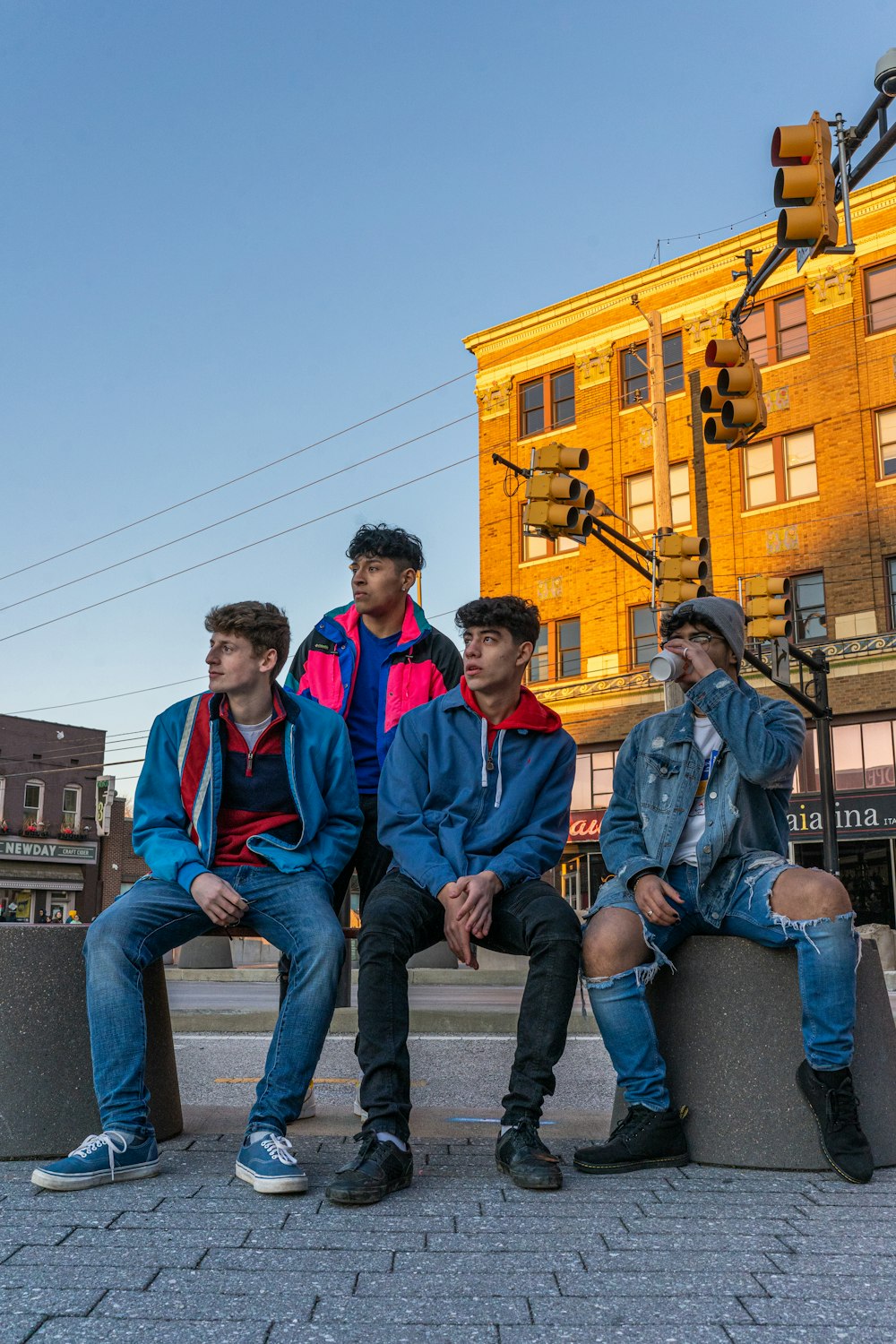 man in red and blue jacket sitting beside man in blue denim jeans