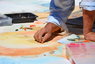 person in white dress shirt painting on white paper