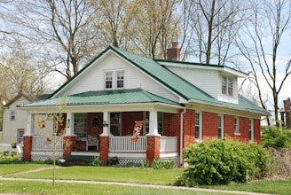 white and brown wooden house near green trees during daytime