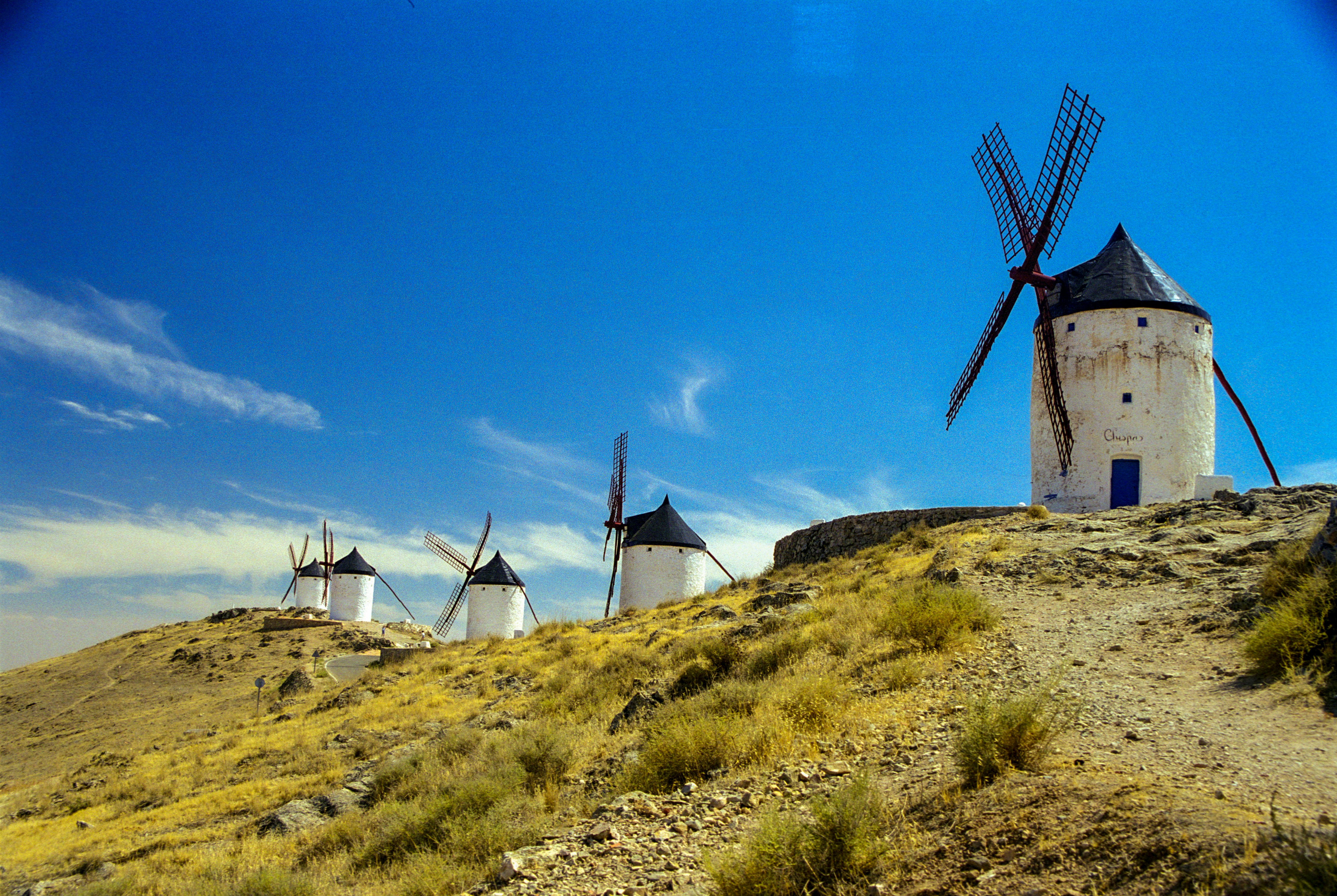 windmill on green grass field under blue sky during daytime