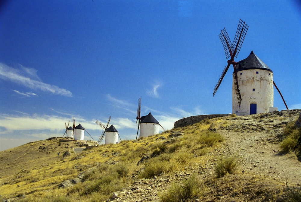 windmill on green grass field under blue sky during daytime