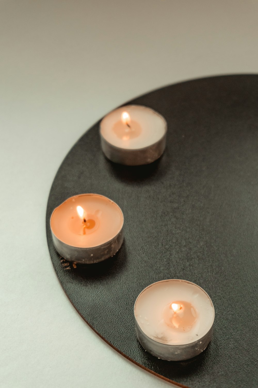 white candle on black round plate