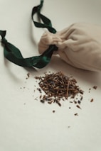 Hands holding a burlap sack filled with dried herbs and tea leaves.